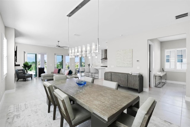dining area with light tile patterned flooring, baseboards, visible vents, and ceiling fan