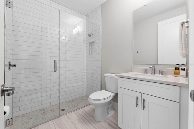 full bathroom with a stall shower, toilet, and vanity