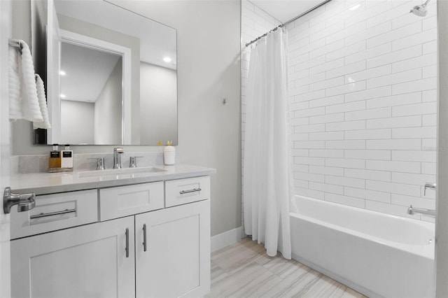 bathroom with shower / bath combo, baseboards, and vanity