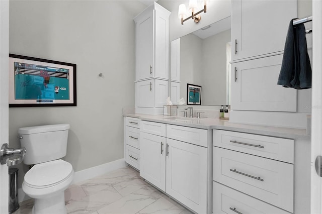 bathroom featuring baseboards, marble finish floor, toilet, and vanity