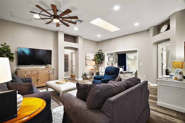2142 Margarita Dr, The Villages, FL 32159 - living area with visible vents, a skylight, a ceiling fan, arched walkways, and dark wood-style floors