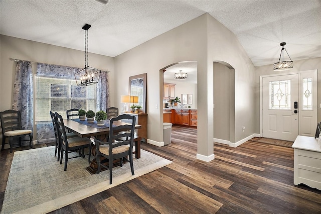 2142 Margarita Dr, The Villages, FL 32159 - dining area featuring vaulted ceiling, baseboards, arched walkways, dark wood-type flooring, and an inviting chandelier