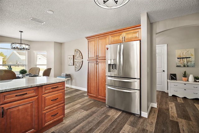 2142 Margarita Dr, The Villages, FL 32159 - kitchen featuring light stone countertops, arched walkways, dark wood-type flooring, stainless steel fridge with ice dispenser, and a notable chandelier