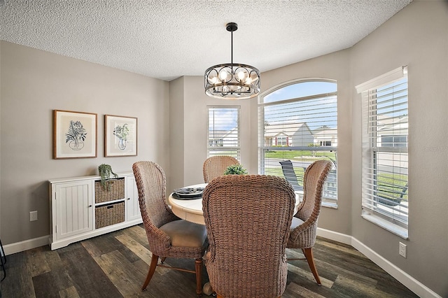 2142 Margarita Dr, The Villages, FL 32159 - dining room with dark wood-type flooring, a textured ceiling, baseboards, and a notable chandelier