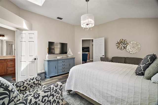 2142 Margarita Dr, The Villages, FL 32159 - bedroom with a notable chandelier, wood finished floors, ensuite bathroom, visible vents, and lofted ceiling with skylight