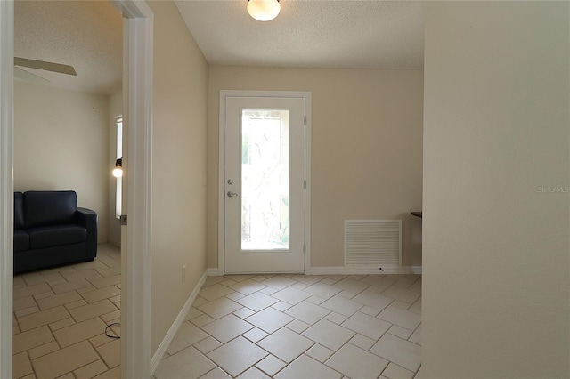 entryway featuring visible vents, a textured ceiling, a ceiling fan, and a healthy amount of sunlight