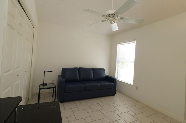 sitting room with baseboards and ceiling fan