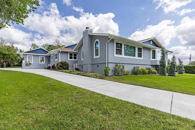 11619 Lane Park Rd, Tavares, FL 32778 - view of front of home featuring a chimney, stucco siding, a front yard, and concrete driveway