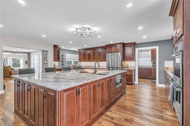 11619 Lane Park Rd, Tavares, FL 32778 - kitchen with stainless steel appliances, light wood-style flooring, plenty of natural light, a spacious island, and recessed lighting