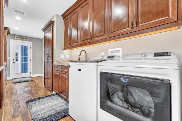 11619 Lane Park Rd, Tavares, FL 32778 - laundry room with cabinet space, light wood-type flooring, and separate washer and dryer