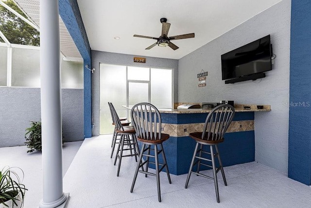 11619 Lane Park Rd, Tavares, FL 32778 - dining space with ceiling fan, a textured wall, and decorative columns