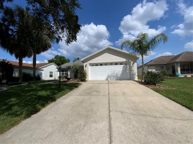 664 San Pedro Dr, The Villages, FL 32159 - single story home with concrete driveway, stucco siding, an attached garage, and a front lawn