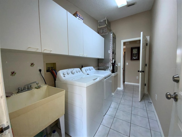664 San Pedro Dr, The Villages, FL 32159 - washroom with visible vents, a sink, cabinet space, separate washer and dryer, and light tile patterned floors