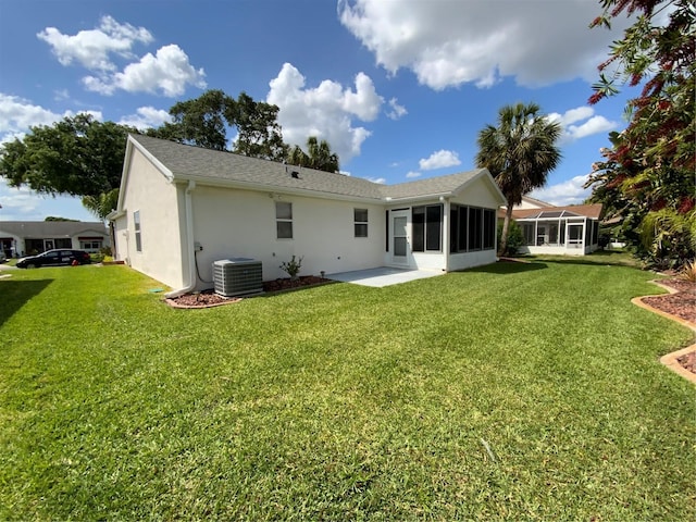 664 San Pedro Dr, The Villages, FL 32159 - back of house featuring cooling unit, a sunroom, stucco siding, a shingled roof, and a yard