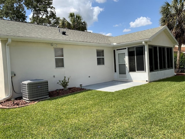 664 San Pedro Dr, The Villages, FL 32159 - back of house featuring stucco siding, a sunroom, central AC unit, and a lawn