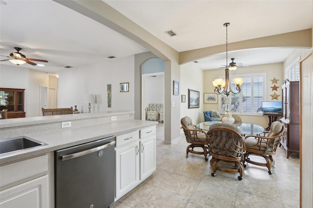 kitchen featuring white cabinets, light countertops, arched walkways, ceiling fan with notable chandelier, and stainless steel dishwasher