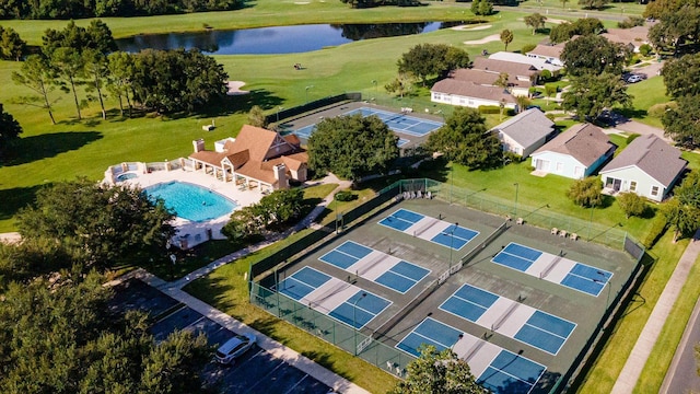 drone / aerial view with view of golf course, a residential view, and a water view