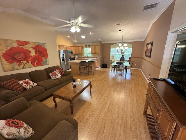 725 Beldon Ct, The Villages, FL 32162 - living area featuring vaulted ceiling, crown molding, a ceiling fan, light wood-type flooring, and a chandelier