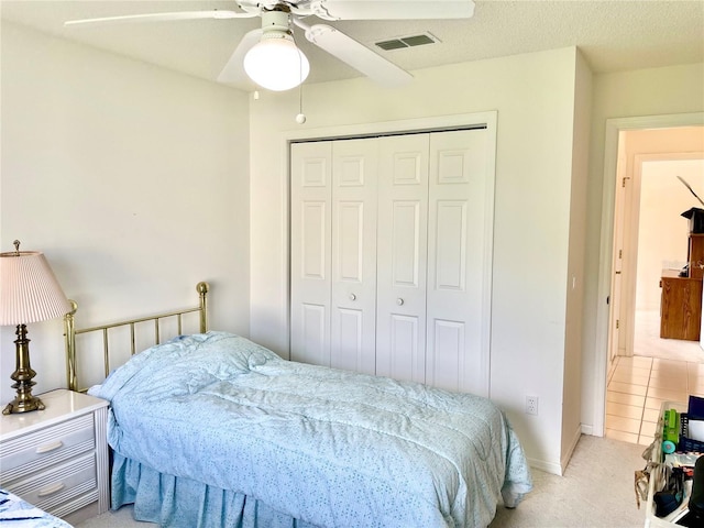bedroom featuring a closet, carpet flooring, visible vents, and a ceiling fan