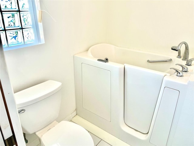 full bath with toilet and a tub to relax in
