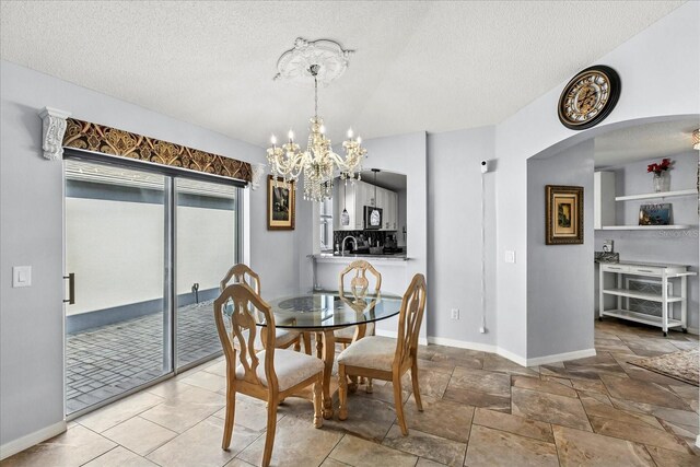 1917 Peachtree Ave, The Villages, FL 32162 - dining room with a chandelier, a textured ceiling, and arched walkways