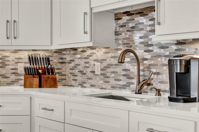 13112 Luntz Point Ln, Windermere, FL 34786 - kitchen featuring a sink, light countertops, decorative backsplash, and white cabinetry