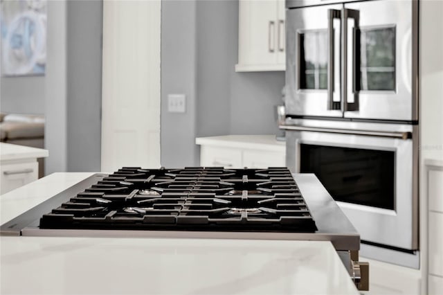 13112 Luntz Point Ln, Windermere, FL 34786 - kitchen with gas cooktop, double oven, white cabinets, and light countertops