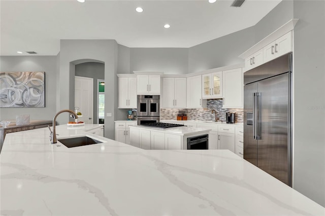13112 Luntz Point Ln, Windermere, FL 34786 - kitchen with stainless steel appliances, a sink, white cabinets, backsplash, and recessed lighting