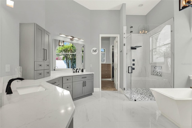13112 Luntz Point Ln, Windermere, FL 34786 - full bath with a shower stall, two vanities, a freestanding tub, marble tiled floors, and baseboards