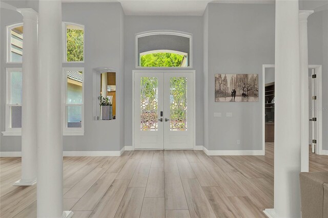 13112 Luntz Point Ln, Windermere, FL 34786 - entryway featuring ornate columns, french doors, light wood-style floors, healthy amount of natural light, and a high ceiling
