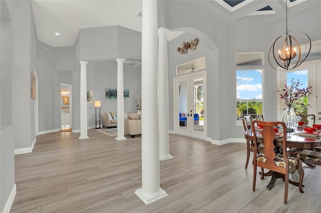13112 Luntz Point Ln, Windermere, FL 34786 - dining area featuring decorative columns, a towering ceiling, a chandelier, baseboards, and light wood finished floors
