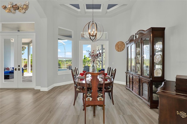13112 Luntz Point Ln, Windermere, FL 34786 - dining space featuring coffered ceiling, a towering ceiling, a chandelier, light wood finished floors, and baseboards