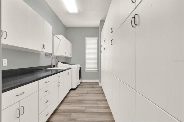 13112 Luntz Point Ln, Windermere, FL 34786 - kitchen featuring a sink, light wood-style flooring, white cabinetry, and separate washer and dryer