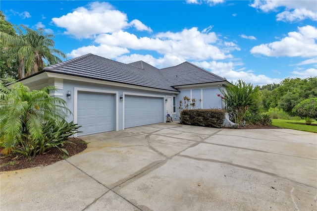 13112 Luntz Point Ln, Windermere, FL 34786 - view of side of home with driveway, an attached garage, stucco siding, and a tile roof