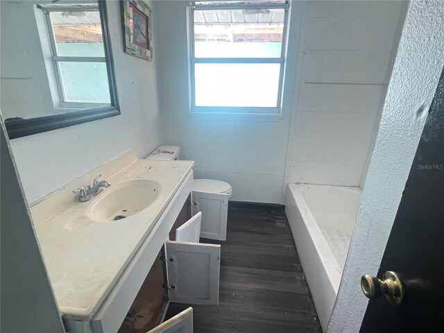 10228 Amadeus Dr, Port Richey, FL 34668 - full bathroom with a shower, wood finished floors, vanity, toilet, and a bath
