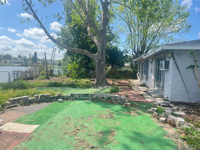 10228 Amadeus Dr, Port Richey, FL 34668 - view of yard featuring a water view, an AC wall unit, and fence