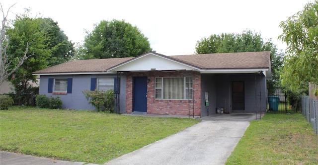 5177 Edwina St, Orlando, FL 32811 - single story home with driveway, an attached carport, fence, brick siding, and a front lawn