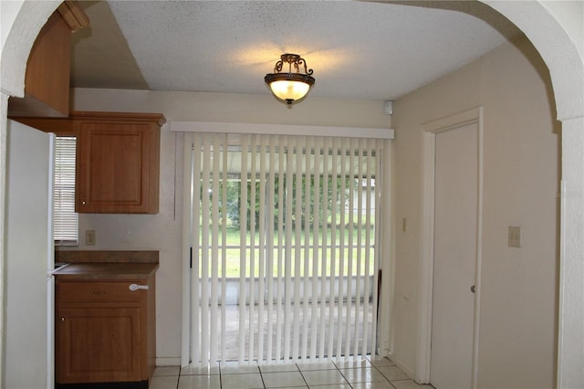 5177 Edwina St, Orlando, FL 32811 - entryway featuring a textured ceiling, arched walkways, and light tile patterned floors