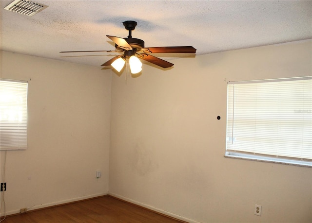 5177 Edwina St, Orlando, FL 32811 - empty room featuring a textured ceiling, visible vents, wood finished floors, and a ceiling fan