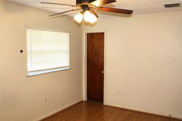 5177 Edwina St, Orlando, FL 32811 - empty room featuring a textured ceiling, visible vents, baseboards, a ceiling fan, and dark wood-type flooring