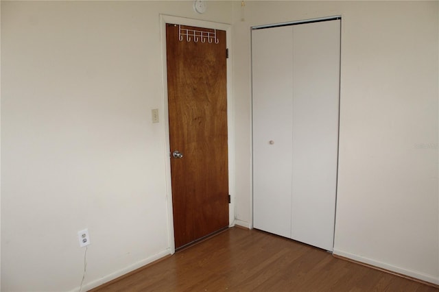 5177 Edwina St, Orlando, FL 32811 - unfurnished bedroom with baseboards, a closet, and wood finished floors