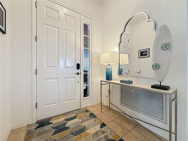 foyer with baseboards and light tile patterned floors