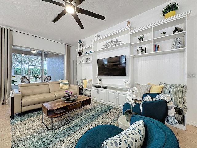 living area featuring a ceiling fan, light tile patterned floors, and a textured ceiling
