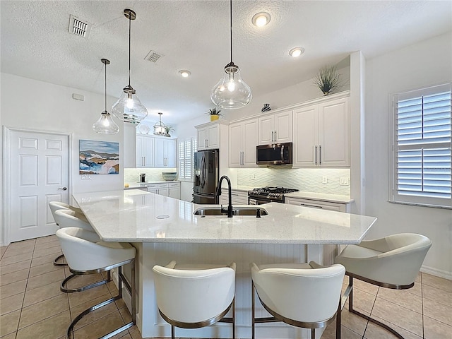 kitchen featuring decorative backsplash, visible vents, a sink, and stainless steel appliances