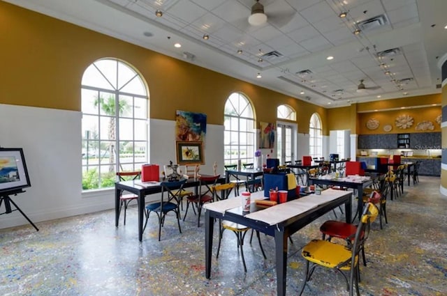 dining area with a high ceiling, baseboards, a healthy amount of sunlight, and a paneled ceiling