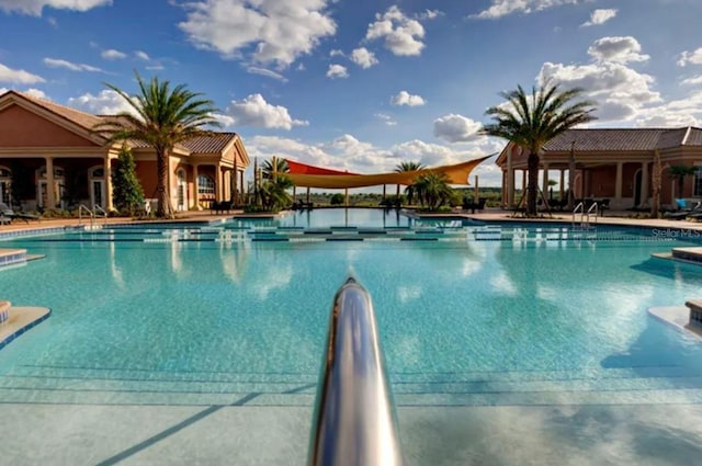 community pool with a water slide and a patio