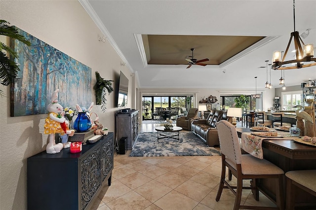 dining area featuring light tile patterned flooring, crown molding, ceiling fan, and a raised ceiling