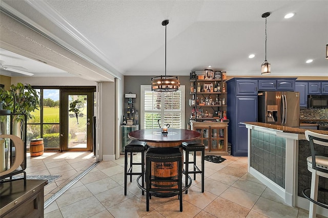 dining area with light tile patterned floors, ornamental molding, and a healthy amount of sunlight