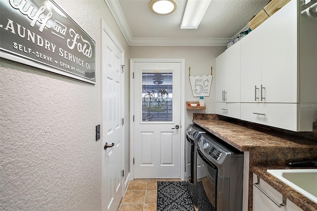 kitchen with white cabinetry, washer and dryer, dark countertops, and ornamental molding