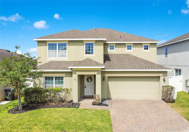 161 Williamson Dr, Davenport, FL 33897 - traditional-style home with a front yard, stucco siding, roof with shingles, and decorative driveway
